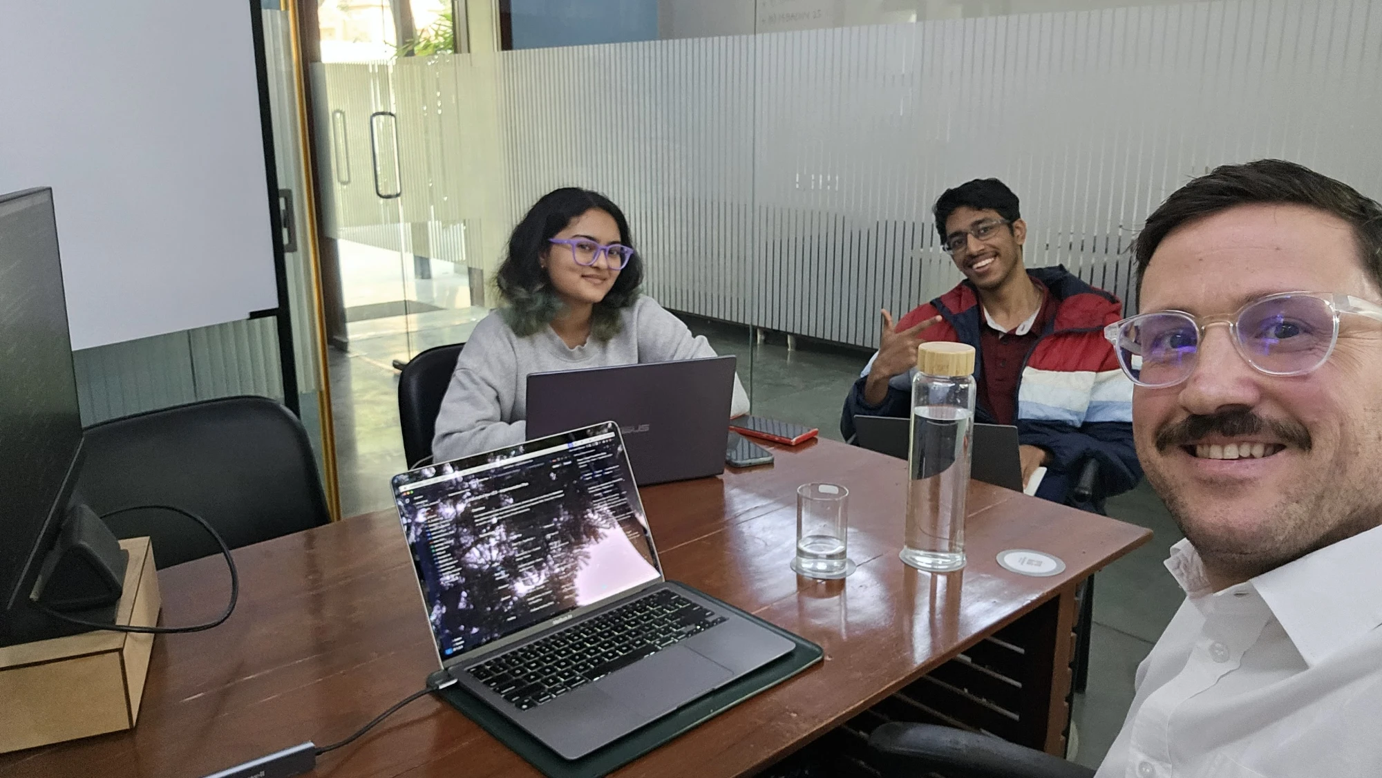 Jeremy Fritzhand in a working session with two founders and their laptops